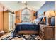Charming bedroom featuring a large window, a ceiling fan, wood-look floors, and stylish furniture at 2117 S Troy Way, Aurora, CO 80014