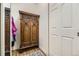 Hallway with hardwood floors featuring an antique cabinet and a white door at 2117 S Troy Way, Aurora, CO 80014