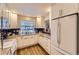 Bright kitchen with white cabinets, granite countertops, and modern appliances at 2117 S Troy Way, Aurora, CO 80014