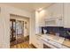 Well-lit kitchen featuring white cabinets and modern appliances with a laundry area nearby at 2117 S Troy Way, Aurora, CO 80014