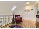 Bright, airy loft area featuring a skylight, hardwood floors, and cozy seating at 2117 S Troy Way, Aurora, CO 80014