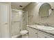 This bathroom features a glass shower, toilet, and a vanity with a round mirror at 13635 E Bates Ave # 404, Aurora, CO 80014