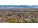 Panoramic aerial view of a vibrant neighborhood, showcasing homes surrounded by lush trees and mountains in the distance at 4035 Fenton Ct, Wheat Ridge, CO 80212