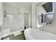 Bright bathroom featuring a soaking tub, glass-enclosed shower, and a large window for natural light at 4035 Fenton Ct, Wheat Ridge, CO 80212