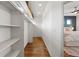 Walk-in closet featuring hardwood floors and custom shelving, leading to bedroom at 4035 Fenton Ct, Wheat Ridge, CO 80212