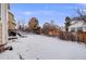 Large backyard with wood fence, featuring a lawn covered with snow, offering great outdoor space at 4821 N Silverlace Dr, Castle Rock, CO 80109