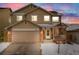 Charming two-story home with a two-car garage and a cozy front porch, surrounded by a snow-covered yard at 4821 N Silverlace Dr, Castle Rock, CO 80109