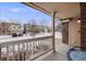 Inviting front porch with seating area, offering a serene view of the neighborhood in a snow-covered landscape at 4821 N Silverlace Dr, Castle Rock, CO 80109