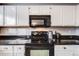 Galley kitchen with white cabinets, black countertops, and black appliances at 4821 N Silverlace Dr, Castle Rock, CO 80109