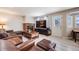 Comfortable living room with brick fireplace, light wood flooring and a door to the backyard at 4821 N Silverlace Dr, Castle Rock, CO 80109