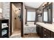 Cozy bathroom with shower, tub, stylish vanity, and wood-look flooring at 3791 Charterwood Cir, Highlands Ranch, CO 80126