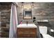Modern bathroom featuring a shower, vanity with sink, toilet, and stylish wood paneling at 3791 Charterwood Cir, Highlands Ranch, CO 80126