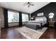 Bright bedroom featuring a ceiling fan, large windows and dark accent wall at 3791 Charterwood Cir, Highlands Ranch, CO 80126