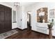 Inviting foyer featuring dark wood floors, a decorative stone alcove, and a stylish front door at 3791 Charterwood Cir, Highlands Ranch, CO 80126