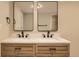 Modern bathroom featuring a double sink vanity with wooden cabinets and sleek black fixtures at 311 Harrison Ave, Fort Lupton, CO 80621