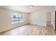 Bright bedroom with wood-look flooring, a window with blinds, and neutral paint at 311 Harrison Ave, Fort Lupton, CO 80621