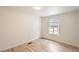 Bright bedroom with wood-look flooring, a window with blinds, and neutral paint at 311 Harrison Ave, Fort Lupton, CO 80621