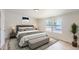 Bright bedroom featuring a large window and a stylish bed with a bench at 311 Harrison Ave, Fort Lupton, CO 80621