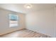 Bright bedroom with wood-look flooring, a window with blinds, and neutral paint at 311 Harrison Ave, Fort Lupton, CO 80621