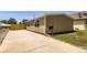 Well-maintained single-story home featuring a concrete driveway, a wooden fence, and a tidy, compact lawn at 311 Harrison Ave, Fort Lupton, CO 80621