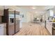 Open floor plan with stainless refrigerator, white cabinets, dining area and living space at 311 Harrison Ave, Fort Lupton, CO 80621