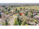 Aerial view of a neighborhood showcasing the house with mature trees, lawns, and surrounding streets at 12423 W 68Th Ave, Arvada, CO 80004