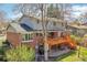 Two-story home's backyard featuring a brick exterior, elevated deck, and a mature tree at 12423 W 68Th Ave, Arvada, CO 80004