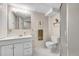 Functional bathroom featuring a toilet, sink vanity, updated mirror, and a shower with glass door at 12423 W 68Th Ave, Arvada, CO 80004