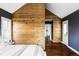 Chic bedroom with a rustic wooden accent wall, white bedding, and a cozy, inviting atmosphere at 4828 W 32Nd Ave, Denver, CO 80212