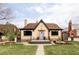 Charming brick home featuring a classic design with a blue front door and a well-maintained front yard at 4828 W 32Nd Ave, Denver, CO 80212