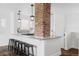 Modern kitchen with white cabinets, granite countertops, an island and brick column at 4828 W 32Nd Ave, Denver, CO 80212