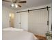 Bedroom featuring a barn door, ceiling fan, and warm natural light at 2158 S Ash St, Denver, CO 80222