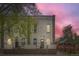Exterior of building at dusk with mature shade tree, arched windows, and an iron fence at 3127 W 28Th Ave # 2, Denver, CO 80211