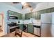 Cozy kitchen featuring stainless steel appliances and unique green cabinets with light countertops at 3127 W 28Th Ave # 2, Denver, CO 80211