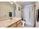 Bathroom featuring a large mirror, shower with curtain and updated fixtures at 5534 Killarney St, Denver, CO 80249