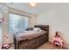 Bedroom featuring a rustic wood storage bed with neutral color walls and window at 5534 Killarney St, Denver, CO 80249