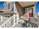 Front porch with a red door and storm door and a view of the two car garage at 5534 Killarney St, Denver, CO 80249
