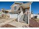 This beautiful home features a two car garage and landscaped yard with a red front door at 5534 Killarney St, Denver, CO 80249
