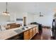 This kitchen has a large island with a sink and view to the Gathering room at 5534 Killarney St, Denver, CO 80249