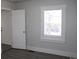 Bright bedroom featuring a window with blinds, a closet, new gray flooring, and fresh paint at 4460 Columbine St, Denver, CO 80216