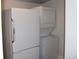 Compact laundry area with a stackable washer and dryer, and a full-size refrigerator at 4460 Columbine St, Denver, CO 80216