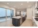 Open concept kitchen with a large island connects to the dining and living areas, with sliding glass doors at 920 Promenade Dr, Superior, CO 80027