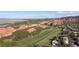 Stunning aerial view of a residential neighborhood near a green golf course and red rock formations in Morrison, Colorado at 11039 Roxborough Dr, Littleton, CO 80125