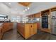Well-lit kitchen featuring an island, modern appliances, wood cabinets, and hardwood floors at 11039 Roxborough Dr, Littleton, CO 80125