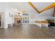 Spacious living room with vaulted ceilings, fireplace, and hardwood floors, illuminated by a modern chandelier at 11039 Roxborough Dr, Littleton, CO 80125