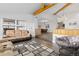 Living room with wood floors open to dining room, features exposed beam and an elegant chandelier at 11039 Roxborough Dr, Littleton, CO 80125