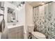 Well-lit bathroom featuring a vanity, a toilet, and shower/tub behind a stylish curtain at 3827 S Fraser St, Aurora, CO 80014