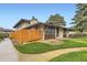 Home featuring a wood fence, tidy landscaping, and a well-maintained exterior at 3827 S Fraser St, Aurora, CO 80014