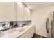 Bright kitchen with white cabinets, neutral countertops, and a view to the dining room at 3827 S Fraser St, Aurora, CO 80014