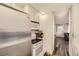 Compact kitchen featuring stainless steel appliances, white cabinets, and hardwood floors at 3827 S Fraser St, Aurora, CO 80014